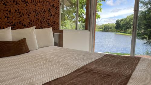 a bedroom with a bed with a view of a lake at Hotel Terramia Resort in Santa Cruz de la Sierra