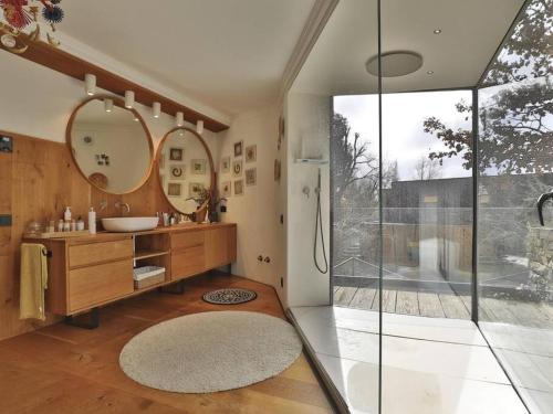 ein Bad mit einem Waschbecken, einem Spiegel und einer Dusche in der Unterkunft Casa japandi Un alojamiento saludable in Sant Juliá de Vilatorta