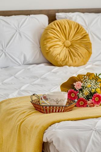 a tray of flowers and a basket on a bed at Ultra Central - Luxurious Retreat in Arad