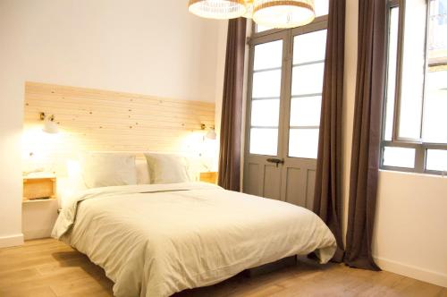 um quarto com uma cama branca e uma grande janela em Apartamento FERROL VELLO II em Ferrol