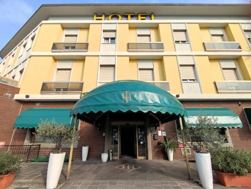 a hotel with a yellow building at Hotel Industria in Brescia