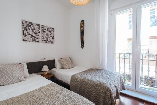 - une chambre avec 2 lits et une fenêtre dans l'établissement Bright Apartment at Santa Cruz 6 pax, Parking Optional, à Séville