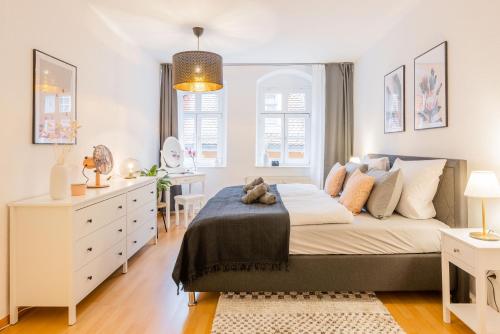 a bedroom with a large bed with a teddy bear on it at Fynbos Apartments in der Altstadt, Frauenkirche, Netflix, Parkplatz in Meißen