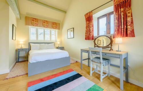 a bedroom with a bed and a desk and a chair at Coursehill Barn in Witney