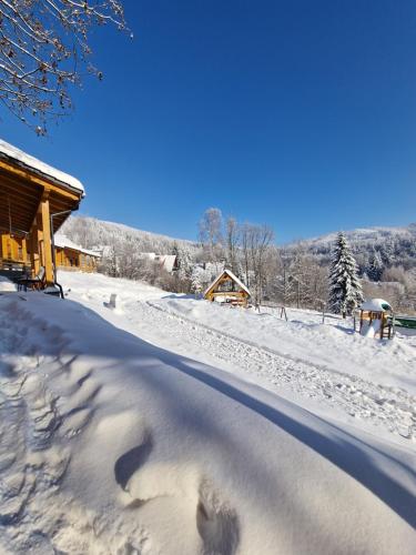 a snow covered road in front of a cabin at Domki pod Jaworem Brenna in Brenna