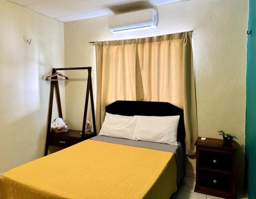 a bedroom with a yellow bed with a window at Zamá house in Palenque