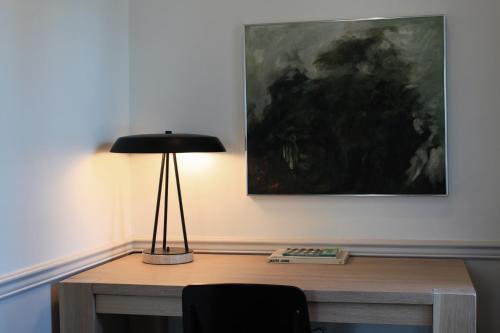 a desk with a lamp and a painting on the wall at Stay Rafa At 2000 Spruce in Philadelphia