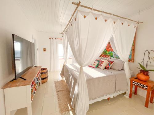 1 dormitorio con 1 cama con dosel en BlowShow Casa I, en Ilhabela
