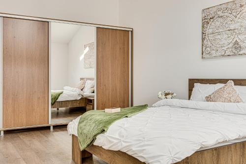 a bedroom with a large bed and a mirror at ARI Central Skyview Apartment in Arad