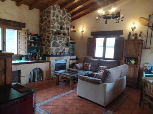 ein Wohnzimmer mit einem Sofa und einem Kamin in der Unterkunft Refugio con Casitas Infantiles in Zamora