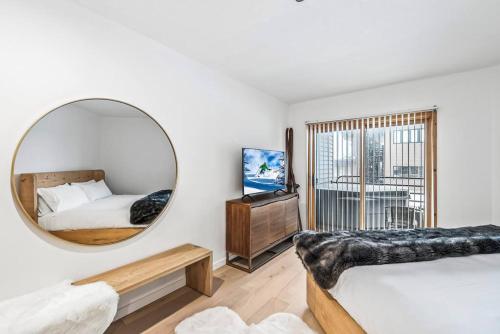um quarto com um espelho, uma cama e uma televisão em Luxe Deer Valley Condo em Park City