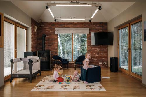 two children playing with toys in a living room at Pensjonat Orle in Krynica Zdrój