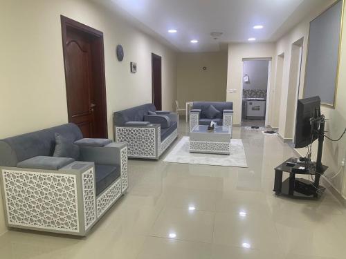 a living room with two couches and a tv at معيذر للشقق المفروشه والفندقية in Doha