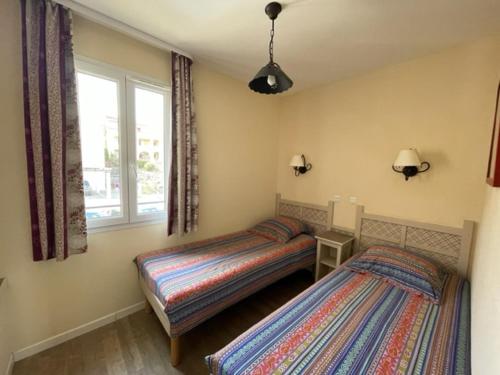 1 dormitorio con 2 camas y ventana en Maison 3 pièces domaine golf Pont Royal en Mallemort