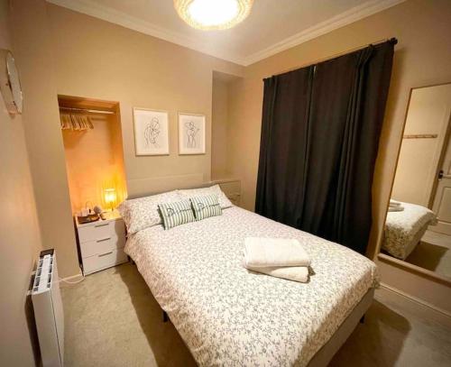 ein kleines Schlafzimmer mit einem Bett und einem Spiegel in der Unterkunft Newly refurbished, central apartment with permit parking in Bath
