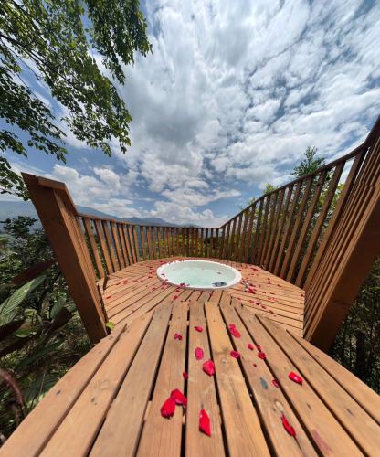 a wooden table with red roses on a wooden deck at Finca Hotel Tierra Verde in Girardota