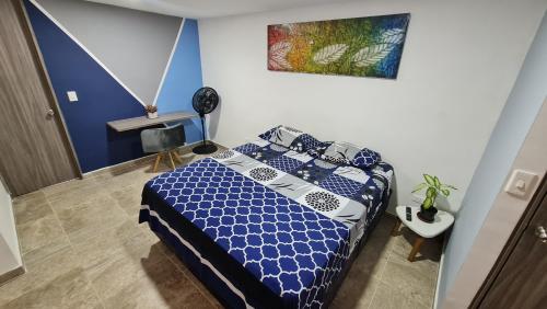 1 dormitorio con 1 cama con sábanas azules y blancas en Aparta Estudio 2 Camas - Parqueadero para Moto - Ibagué - Ciprés, en Ibagué