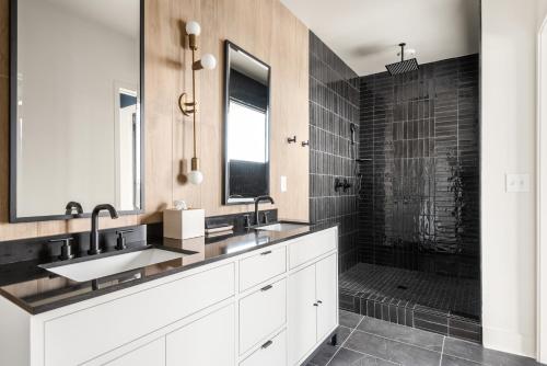 Un baño con dos lavabos y una ducha. en The Eighteen by Mint House, en Nashville