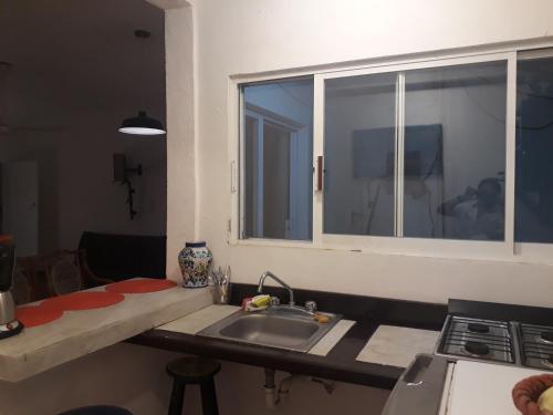 cocina con fregadero y ventana en Bea rooms and studios en Cozumel