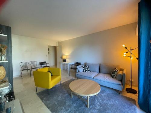 salon z kanapą i stołem w obiekcie C012-Appartement confortable avec piscine, tennis et grand parc w Cannes