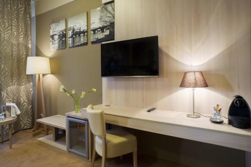 a living room with a tv and a coffee table at Pytloun Kampa Garden Hotel Prague in Prague