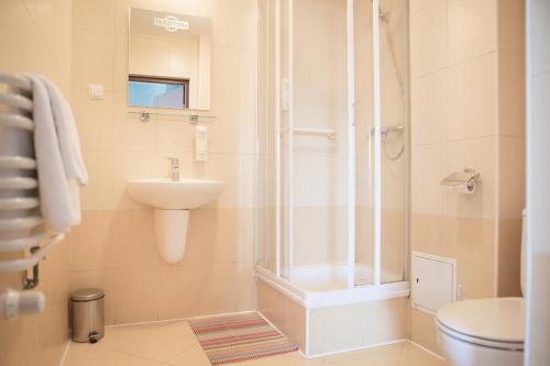 uma casa de banho com um chuveiro, um lavatório e um WC. em Hotel Na Rogatce em Lublin
