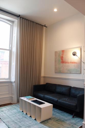 a living room with a black couch and a coffee table at Stay Rafa At 2000 Spruce in Philadelphia