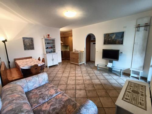 sala de estar con sofá y cocina en Appartamento I Castagneti, en Pasturo