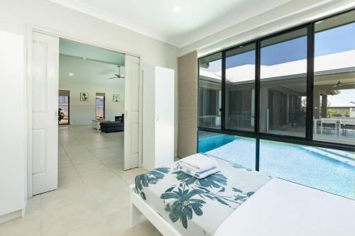 um quarto com uma cama e uma piscina em Family Paradise;Elegant 4BR King bed; Pool and BBQ em Trinity Beach