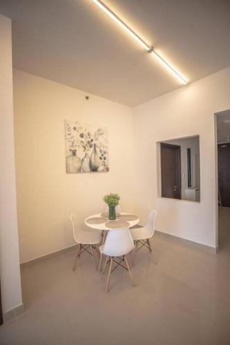 a dining room with a table and chairs and a painting at We love having you here in Abu Dhabi