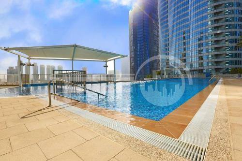 a swimming pool on top of a building with tall buildings at We love having you here in Abu Dhabi