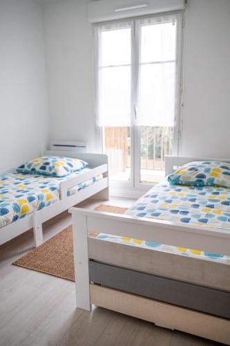 une chambre avec deux lits et une fenêtre dans l'établissement Eirene - Chessy, à Chessy