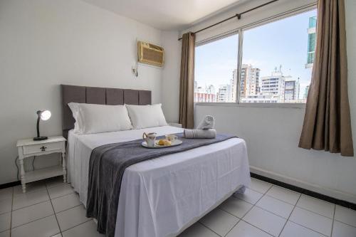 Un dormitorio con una cama con una bandeja de comida. en CLR83 - Calçadão, 1 Dorm Climatizado, Garagem, en Balneário Camboriú