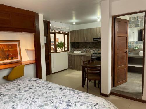 1 dormitorio con 1 cama y cocina con mesa en Charming and impeccable 1-Bed Studio in Huanchaco, en Huanchaco