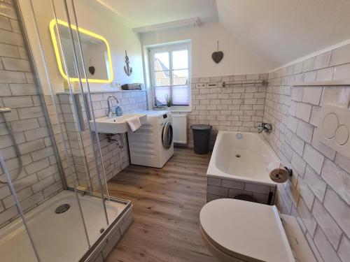 Un baño con inodoro, lavabo y ducha. en Ferienhaus Ellen, OG Whg, en Utersum