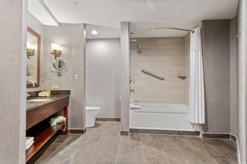 a bathroom with a tub and a toilet and a sink at Wyndham Garden Baronne Plaza in New Orleans