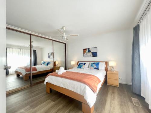 sypialnia z 2 łóżkami i dużym lustrem w obiekcie Penlink Lodge - Base To Explore Mornington Peninsula w mieście Langwarrin