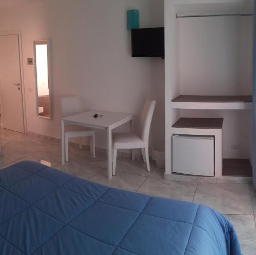 a bedroom with a bed and a table and a desk at Sweet Suite Margherita in Margherita di Savoia