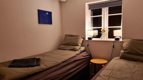 a room with two beds and a window at Sydfynsk idyl tæt på det hele. in Svendborg
