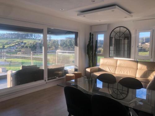 a living room with a couch and a glass table at Apartamento 3 habitaciones Miramar, Luanco in Luanco