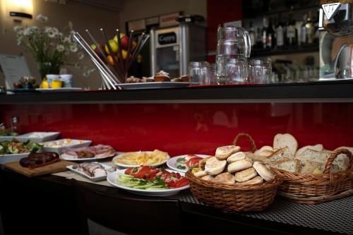 a buffet with plates of food and baskets of bread at Pensjonat Orle in Krynica Zdrój