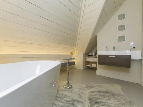 a bathroom with a bath tub and a sink at 338 - Le Quai des Veuves - Les Immeubles Charlevoix in Baie-Saint-Paul