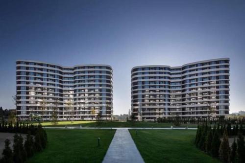 two tall buildings with a grassy field in front at Beautiful Apartment with year round hot mineral pool and jakuzi in Varna City