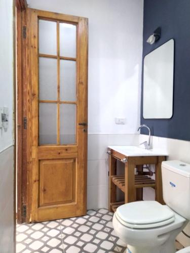 a bathroom with a toilet and a sink and a door at La Soñada in La Paz