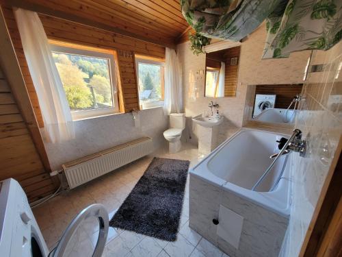 a bathroom with a tub and a toilet and a sink at Chata Claudia in Zázrivá