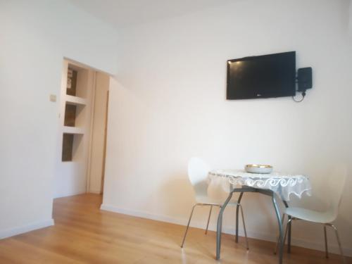 a table and chairs in a room with a tv on the wall at Mieszkanie ul Przędzalniana in Białystok