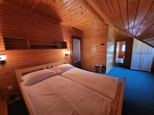 a bedroom with a bed in a wooden room at Chata Claudia in Zázrivá