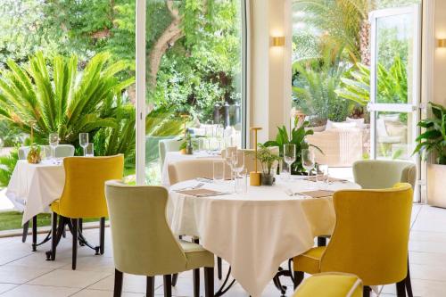 a dining room with tables and yellow chairs at Best Western Premier Montfleuri in Sainte-Maxime