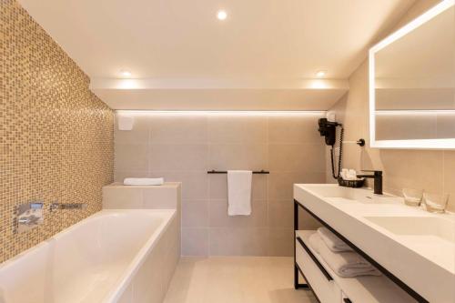 a bathroom with a tub and a sink at Best Western Premier Montfleuri in Sainte-Maxime