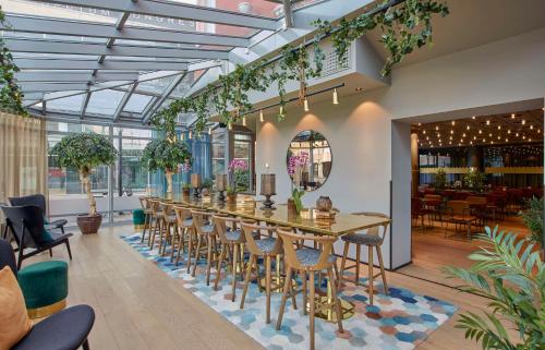 eine Bar mit Stühlen und einem langen Tisch in einem Restaurant in der Unterkunft Scandic Grand Hotel in Örebro